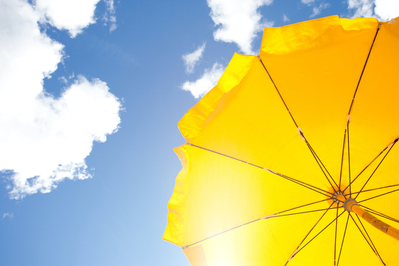 yellow umbrella and blue sky with clouds