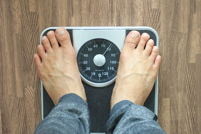 man's feet on weight loss scale